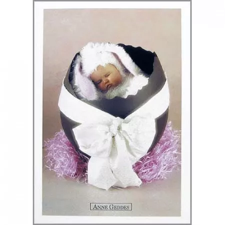 Pohlednice Anne Geddes, miminko v kostýmu králíčka ve vajíčku s bílou mašlí